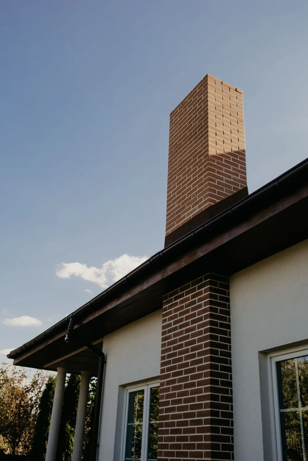 Vivienda unifamiliar con chimenea de ladrillo vista desde el jardín